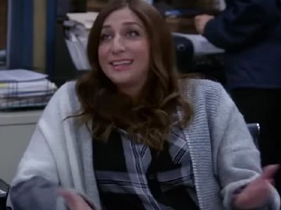 Chelsea Peretti is sitting in her chair as she is speaking.